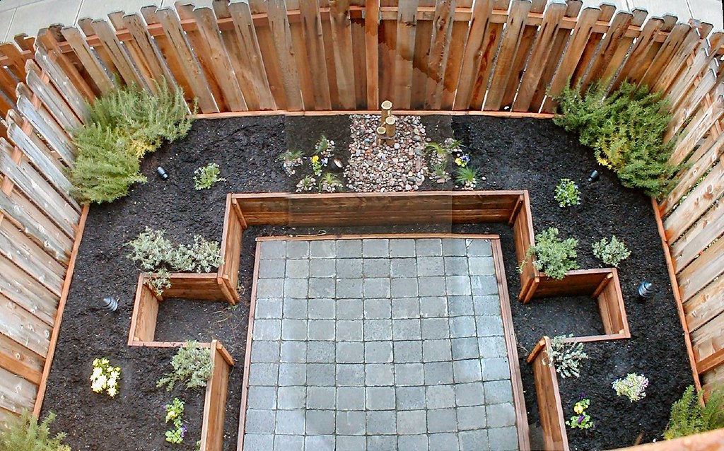 Landschaftsgärtner verlegt Natursteinplatten für eine Gartenterrasse